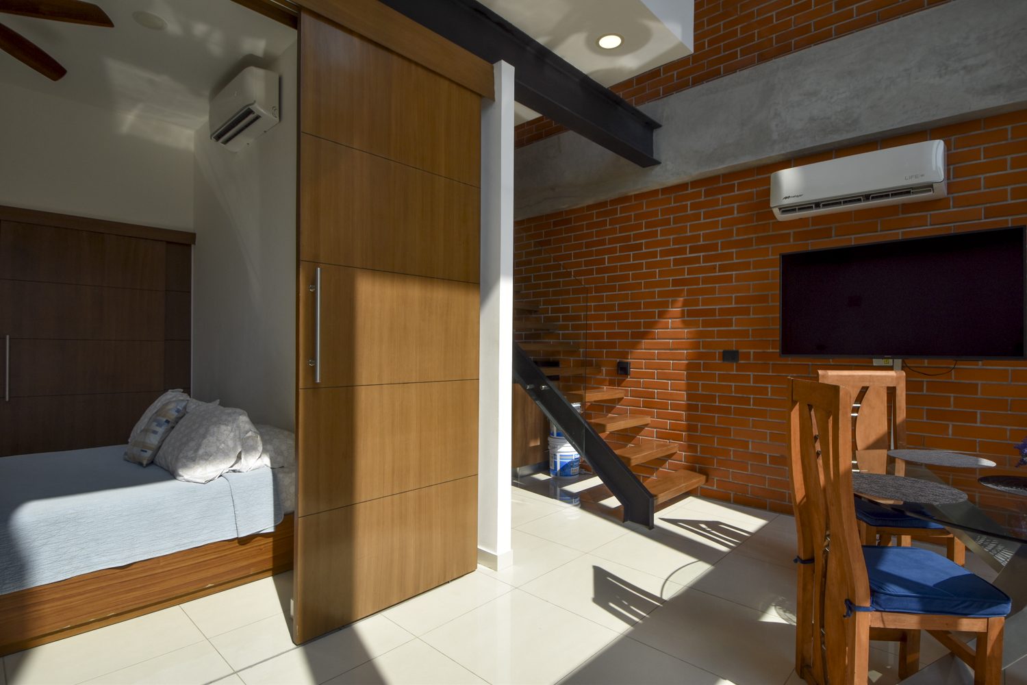 Bedroom, sliding partition and staircase in the open-plan main level