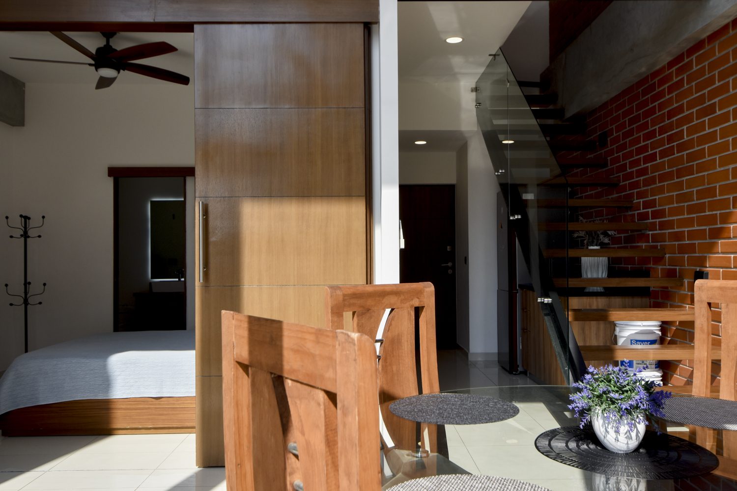 Bedroom with sliding wood door, coat stand and view to the entry and floating staircase, Zoho Skies 108