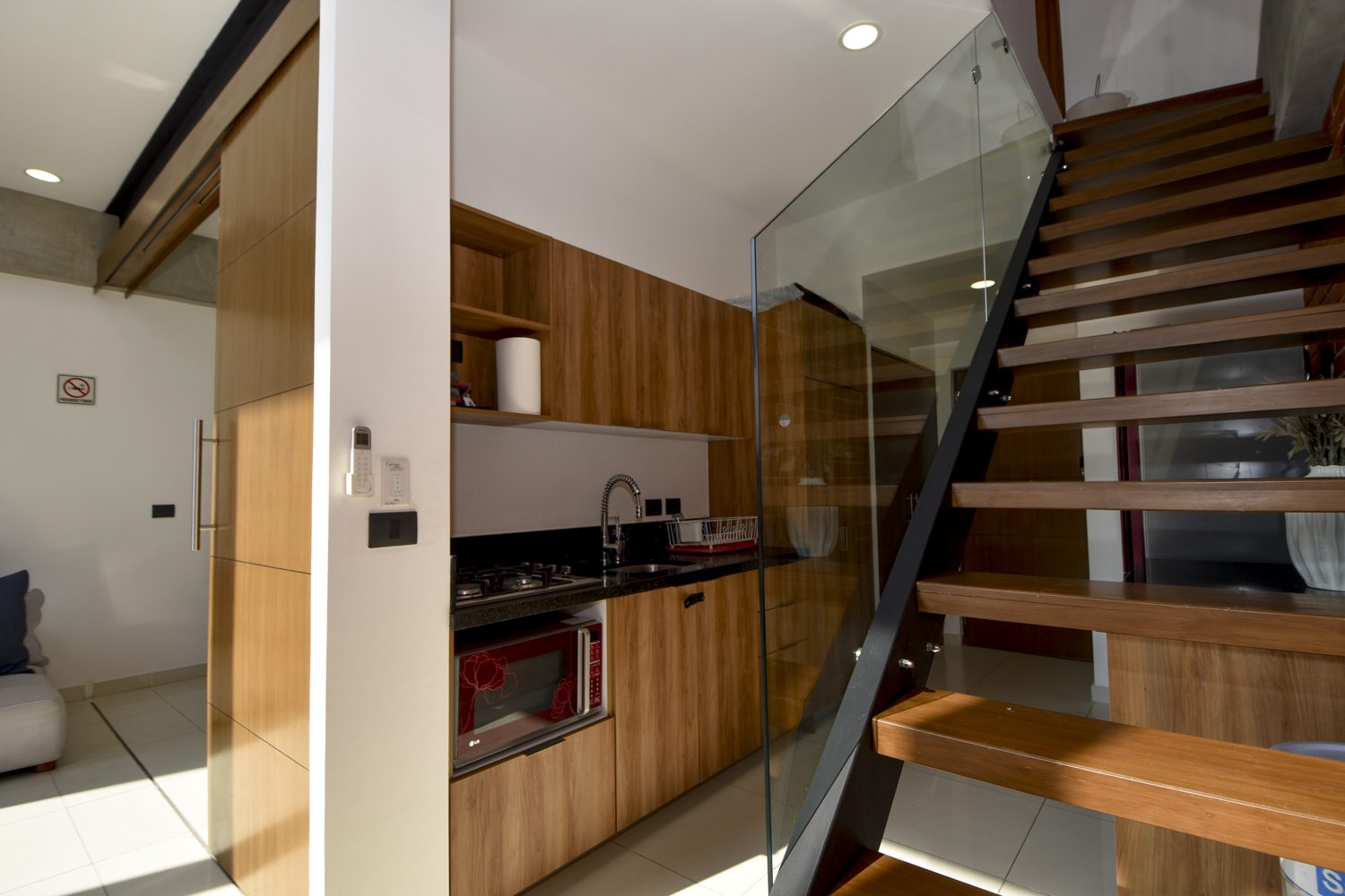 Glass-railed staircase to the second level beside the kitchen